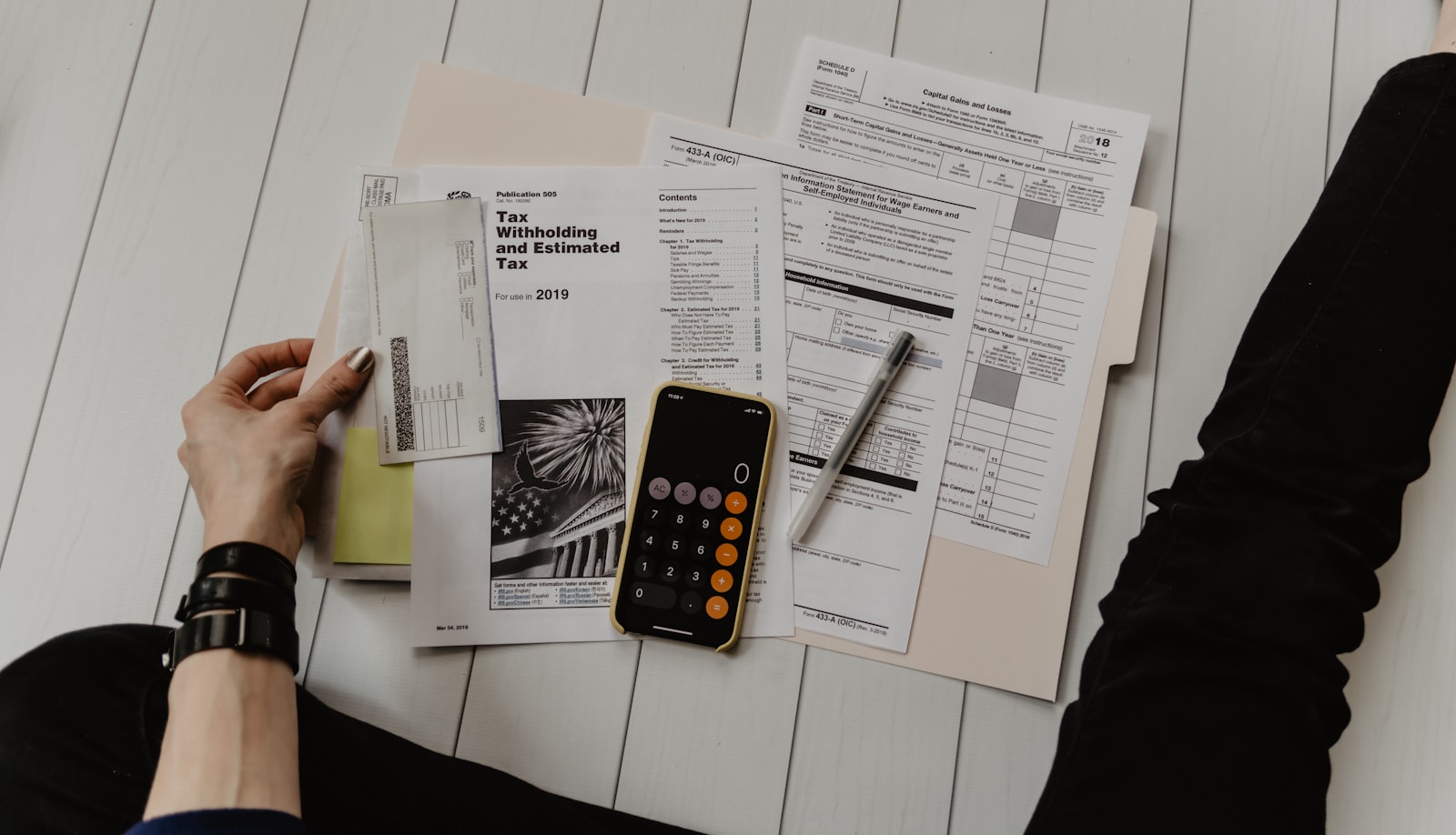 Person reviewing banking and finance documents with a calculator